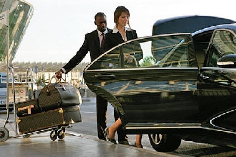 Professional chauffeur holding name board at Dubai airport arrivals — meet and greet service